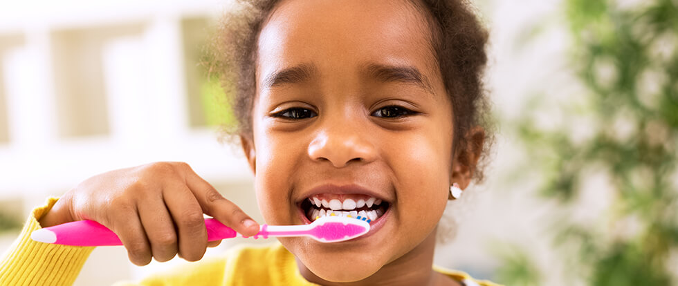 young girl brushing her teeth