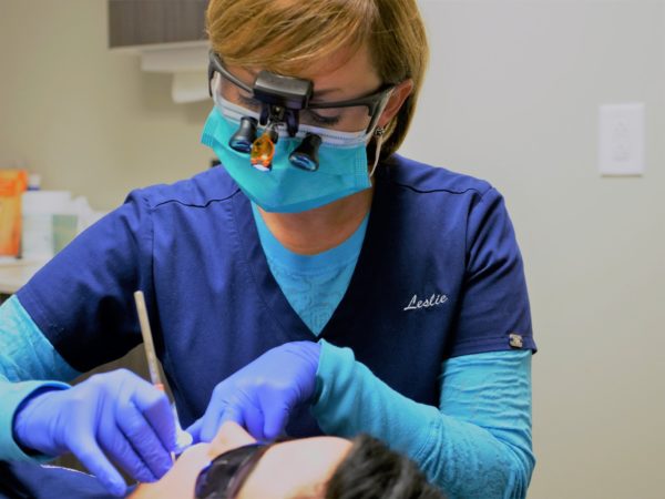 Leslie the dental hygienist cleans a patient's teeth at Bethea Family Dentistry