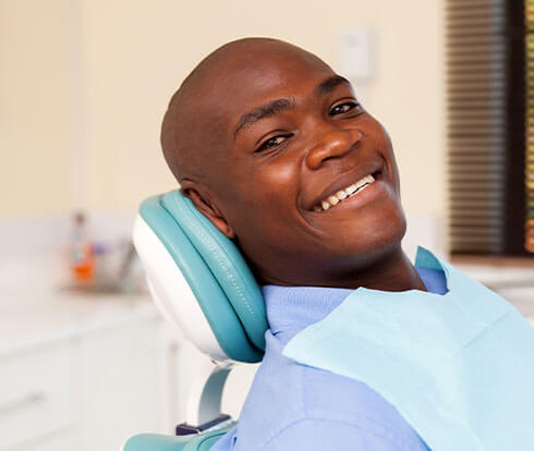 Man sitting in dental exam chair waiting for his root canal procedure