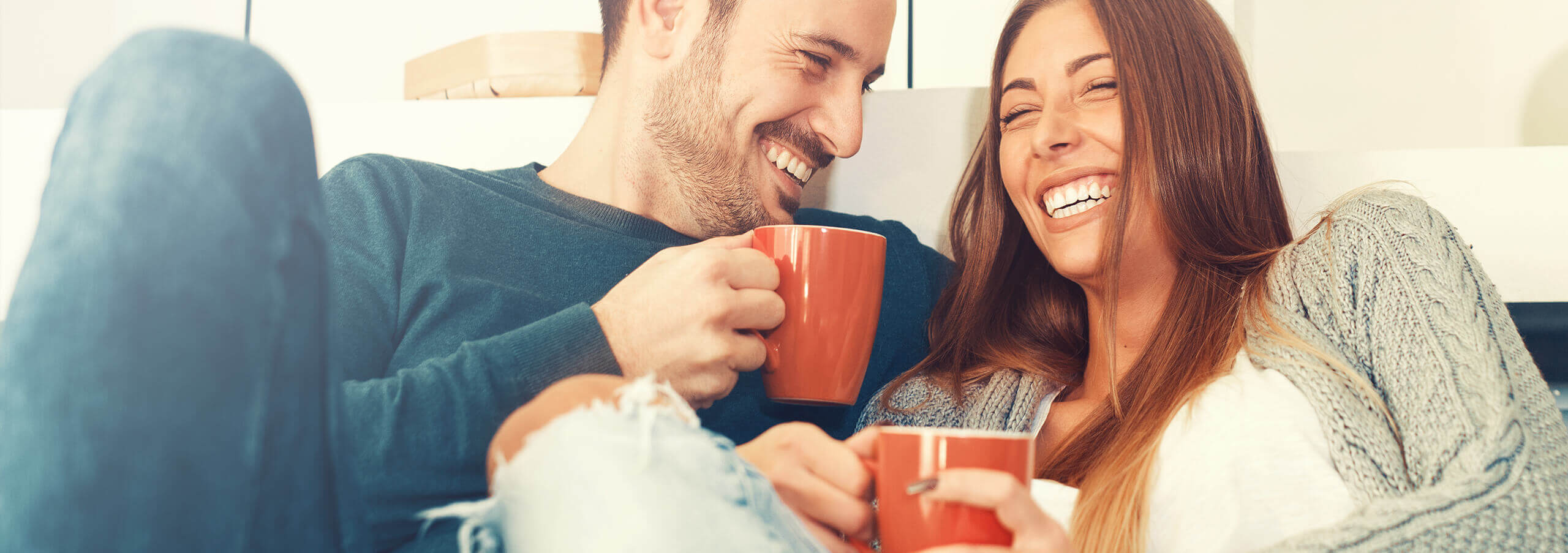 couple sitting on a couch drinking coffee