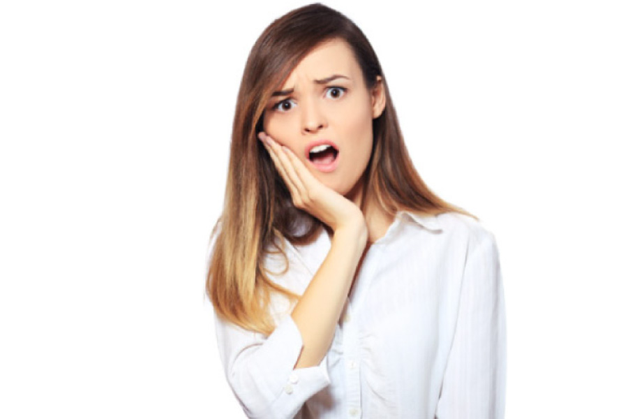 young woman holding her jaw in pain from a dental emergency