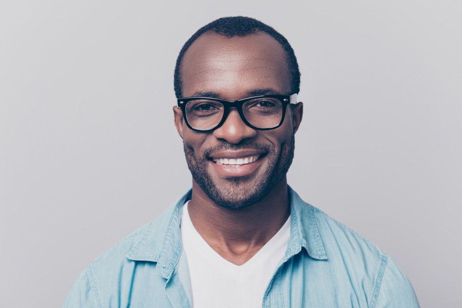Photo of a smiling black man with glasses.