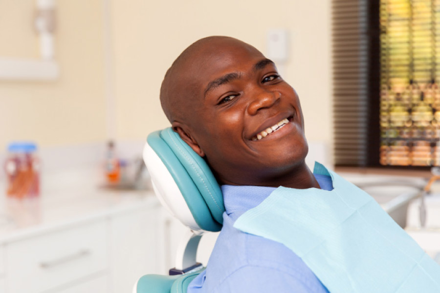 A smiling man in the dental chair for an exam and cleaning.