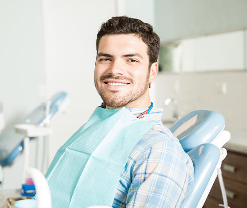 smiling man sitting in a dental chair