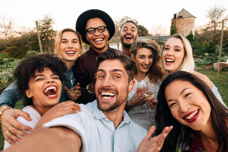 A smiling group of multicultural young adults taking a selfie.