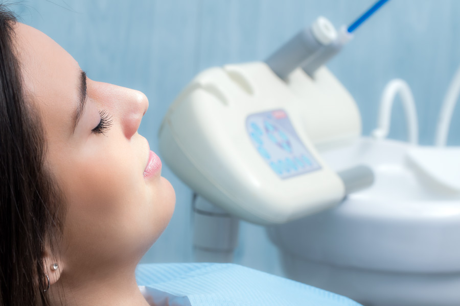 A women with her eyes closed relaxing in the dental chair after dental sedation.